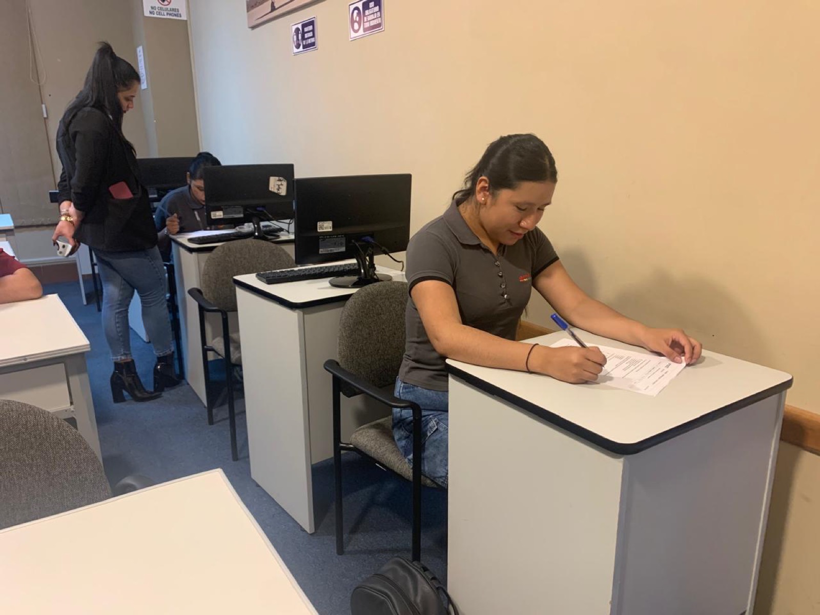 Alumnos trabajando en computadoras en la sede AMASFLY